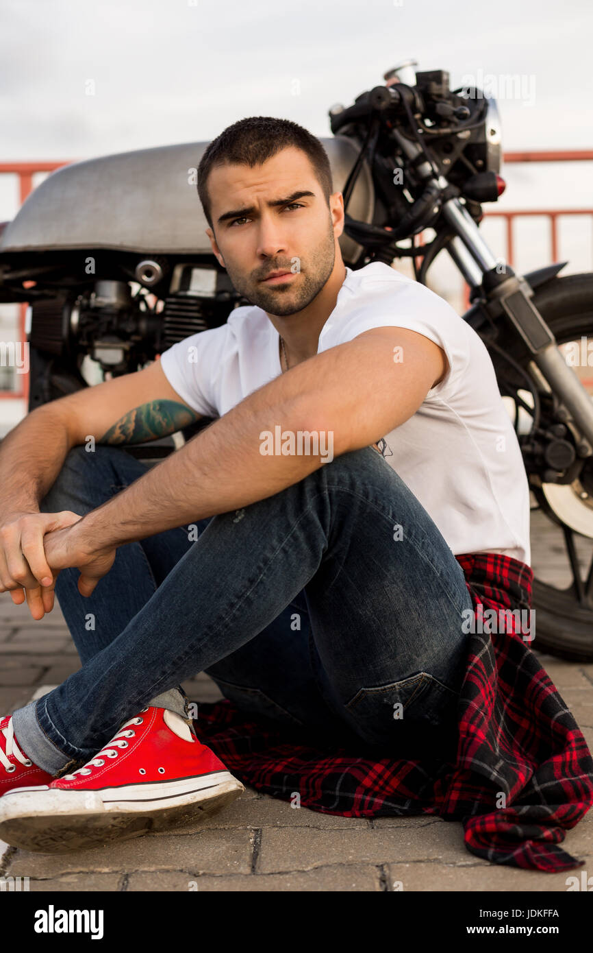 Rider guy with beard and mustache in white tshirt and red sneakers