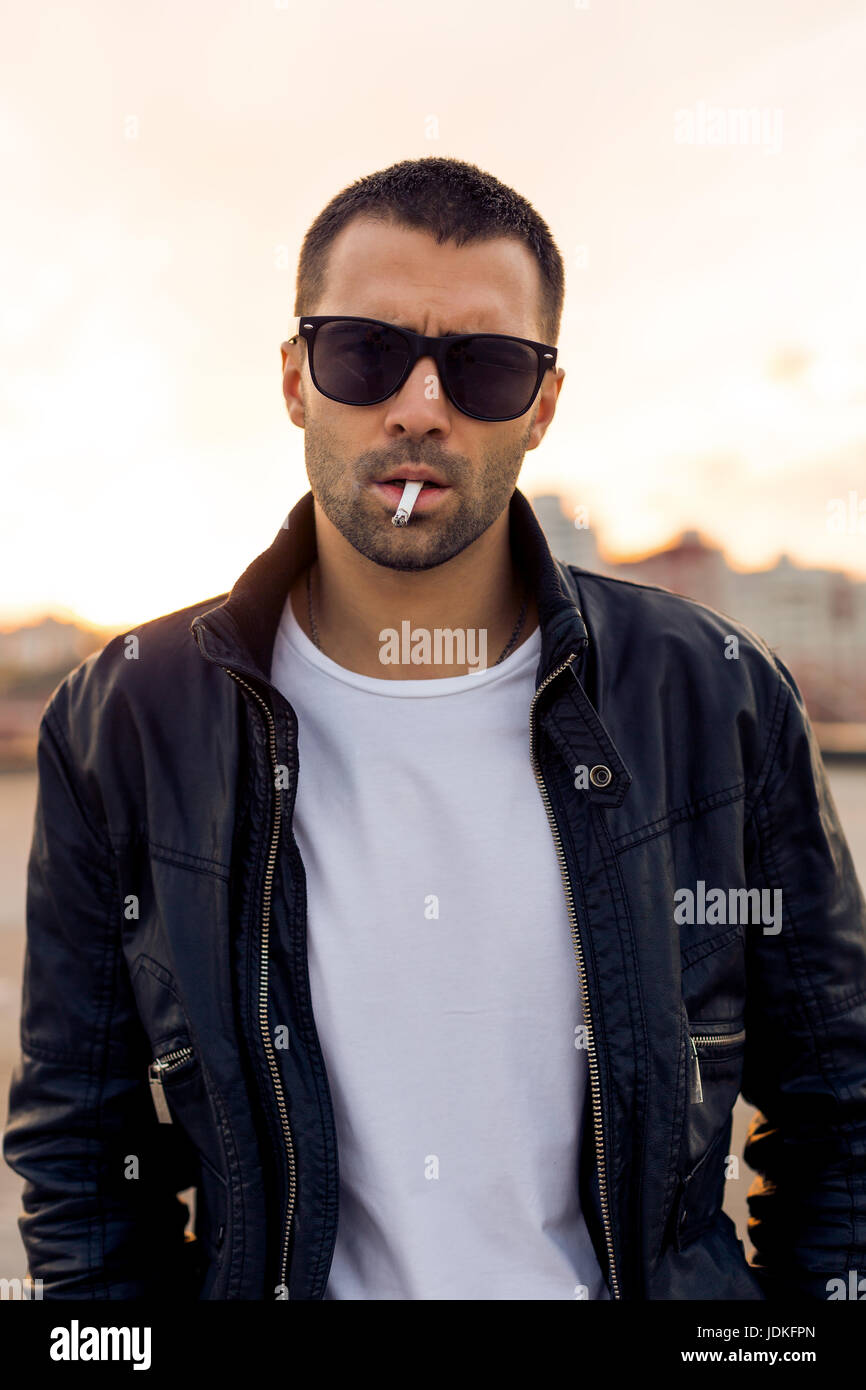 Close up of a handsome rider man with beard and mustache in black biker ...