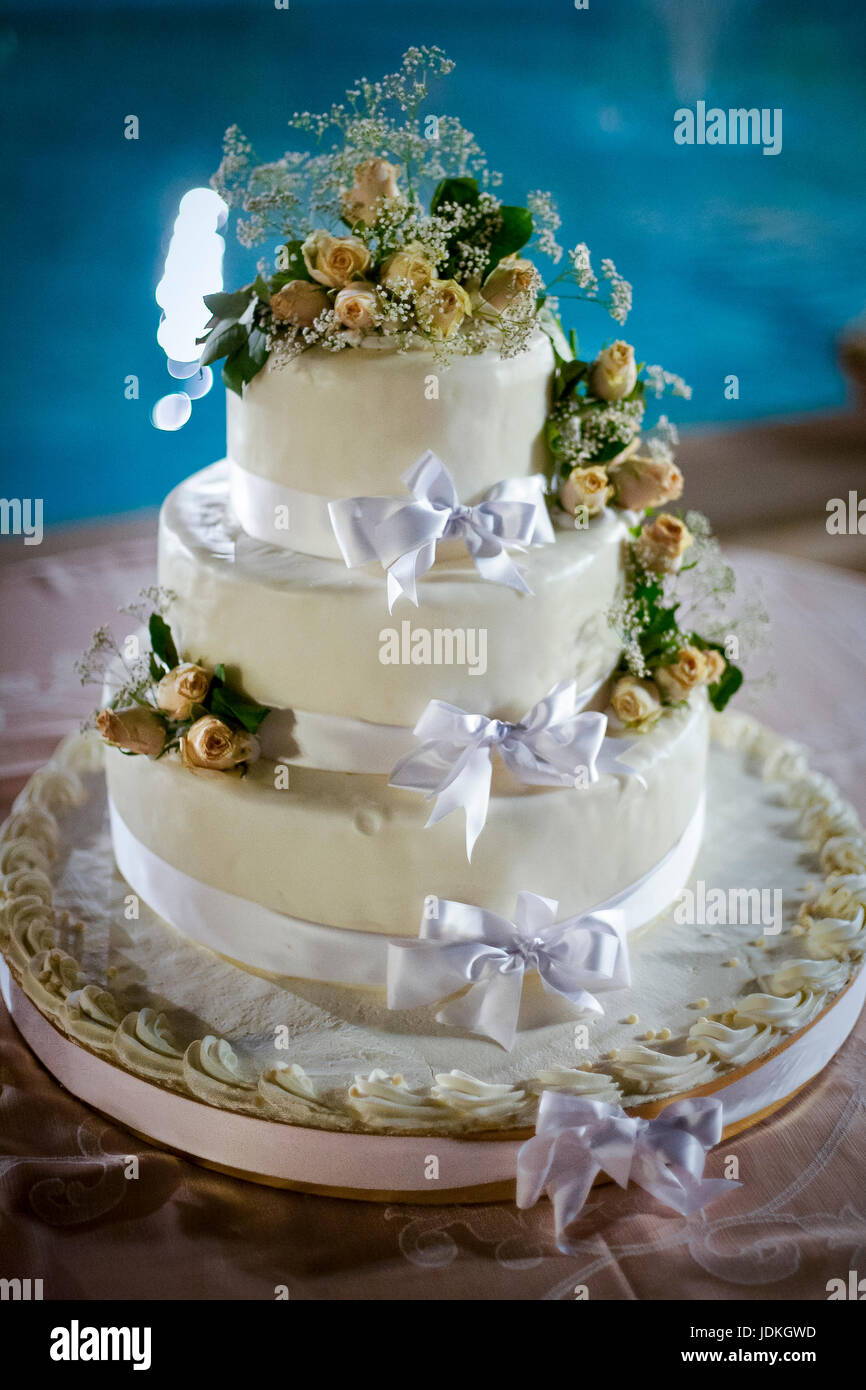 three-tiered withe wedding cake with yellow roses Stock Photo - Alamy