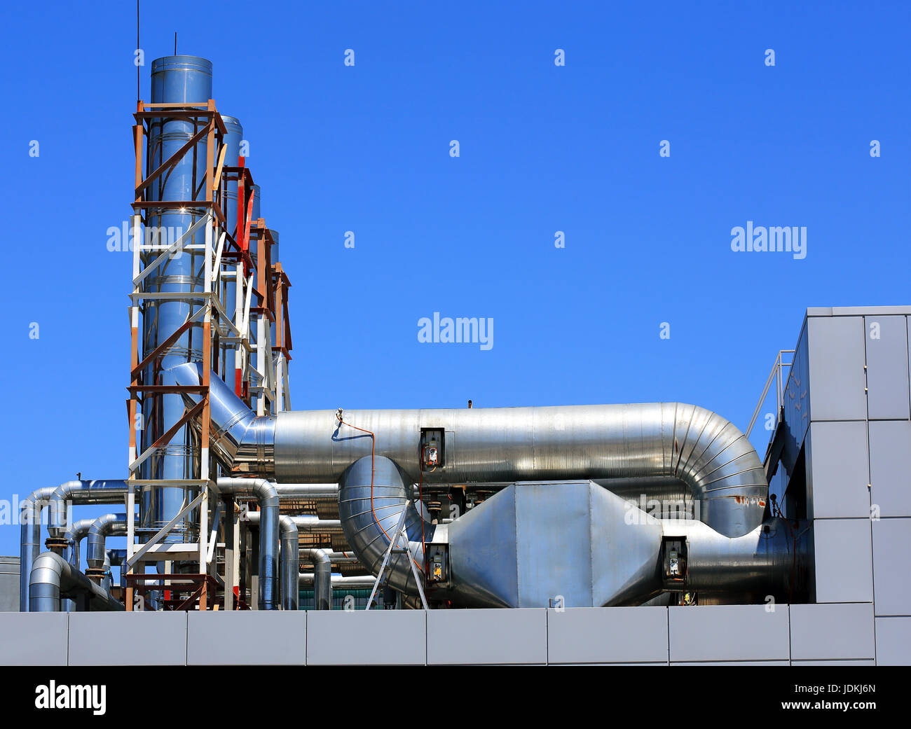Ventilation pipes and actuators on the roof of an industrial building Stock Photo