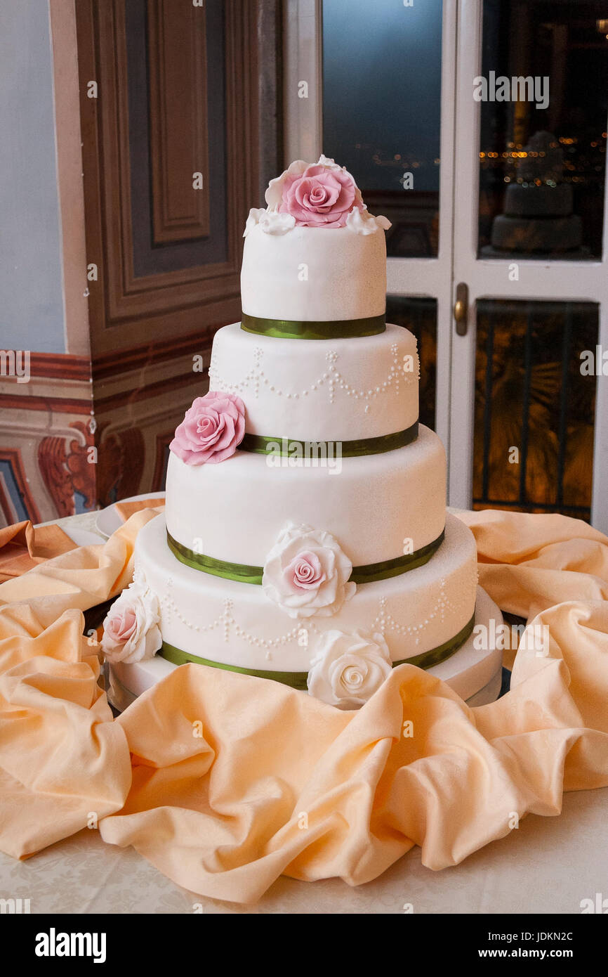 four-tiered withe wedding cake covered with pink roses Stock Photo - Alamy