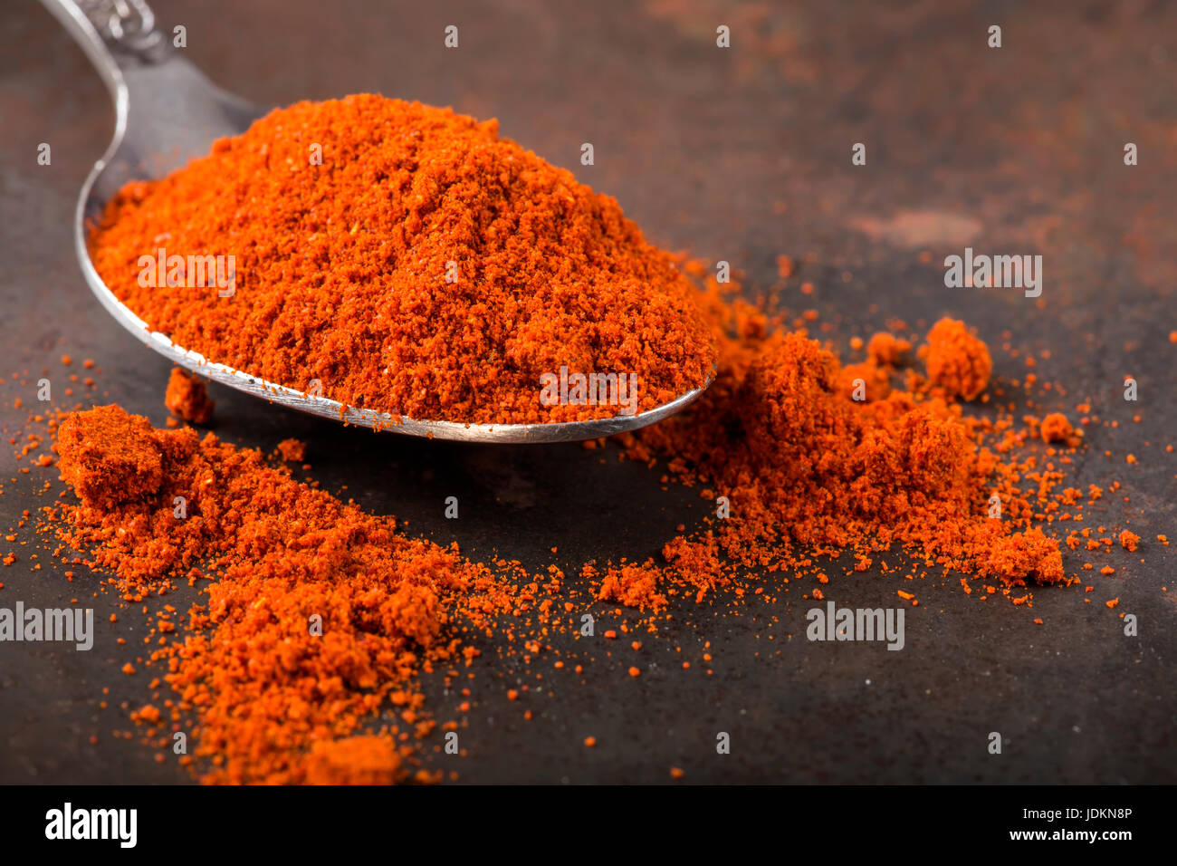 Spoon filled with paprika powder on rusty background Stock Photo Alamy
