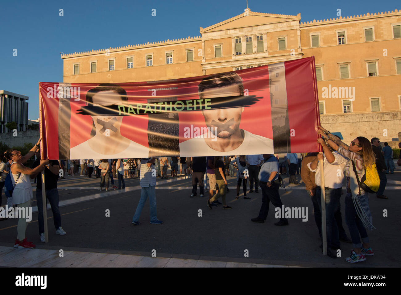 Protesters wave Greek flags and placards as they shout slogans. More ...