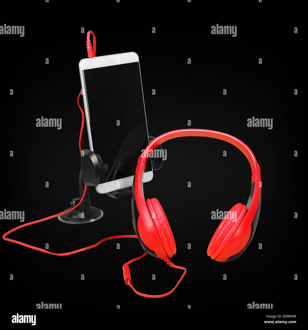 Musical equipment - Red headphone and smartphone on a black background. Stock Photo