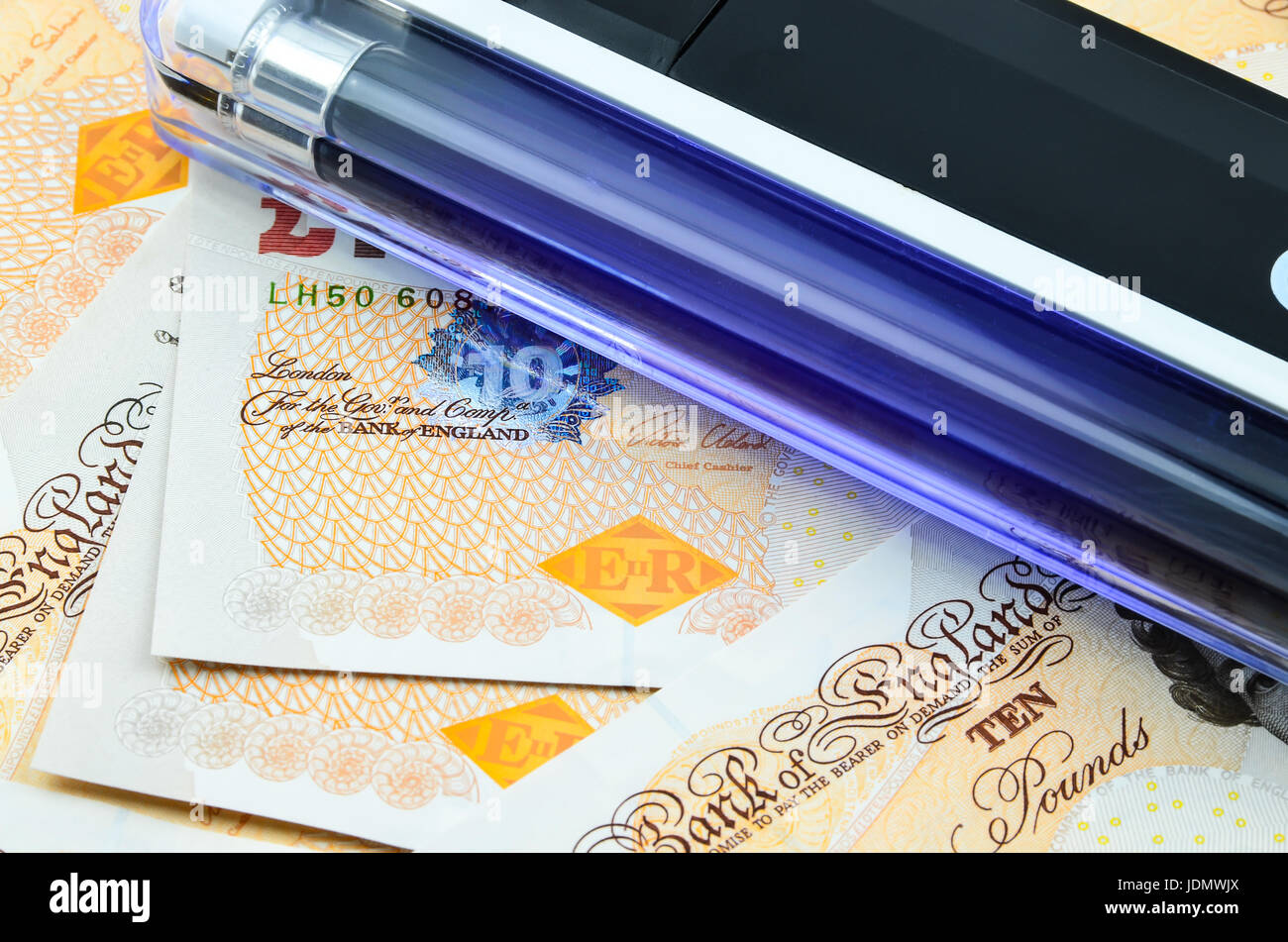 Handheld UV light over banknotes Stock Photo