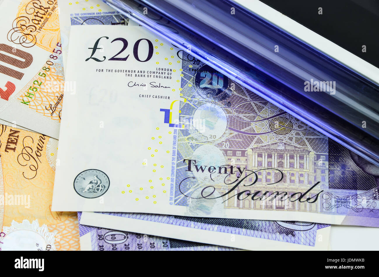 Handheld UV light over banknotes Stock Photo