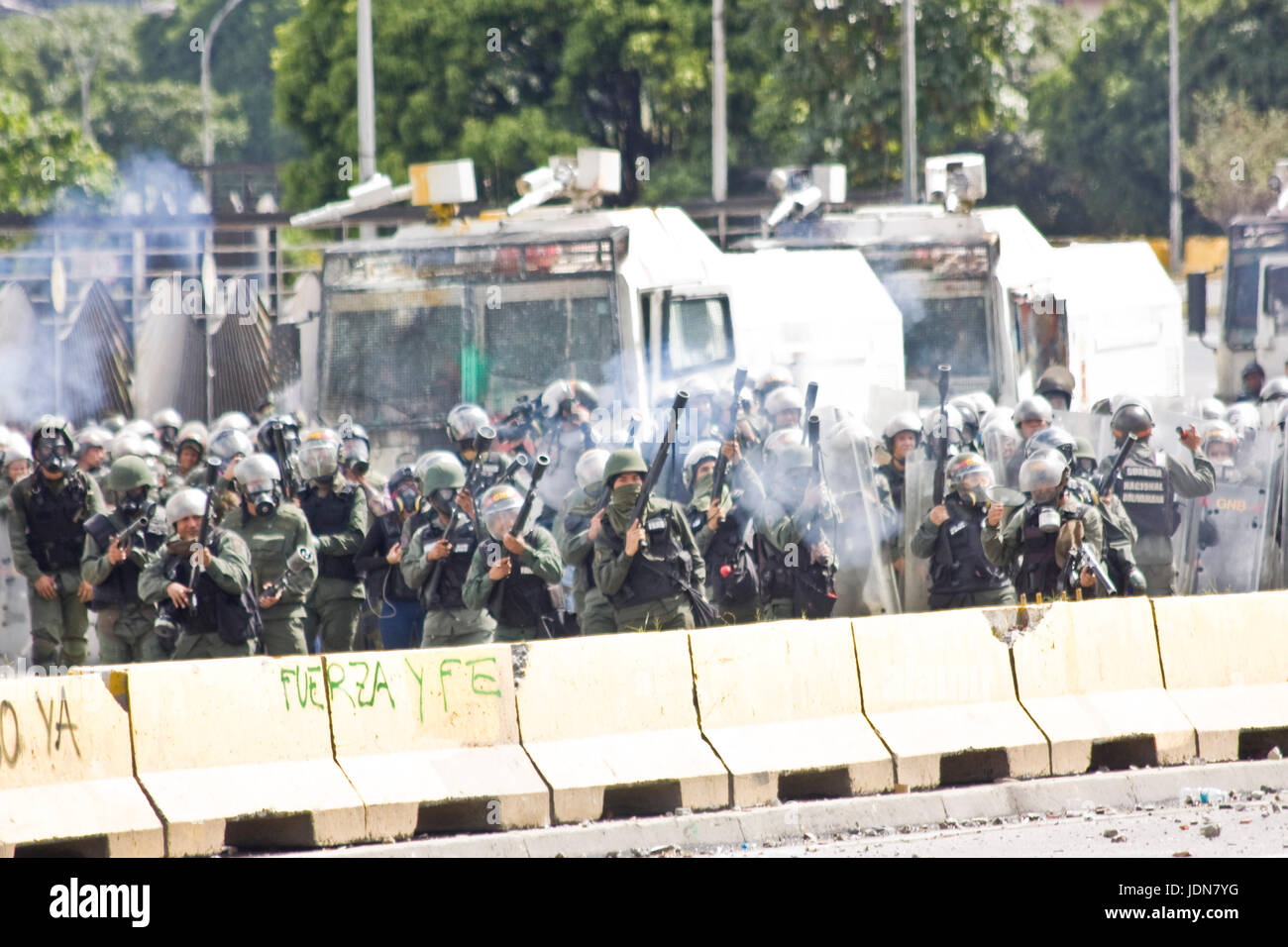 Members of the Bolivarian National Guard open fire against demonstrators during a protest against the government of Nicolas Maduro in Caracas. Stock Photo