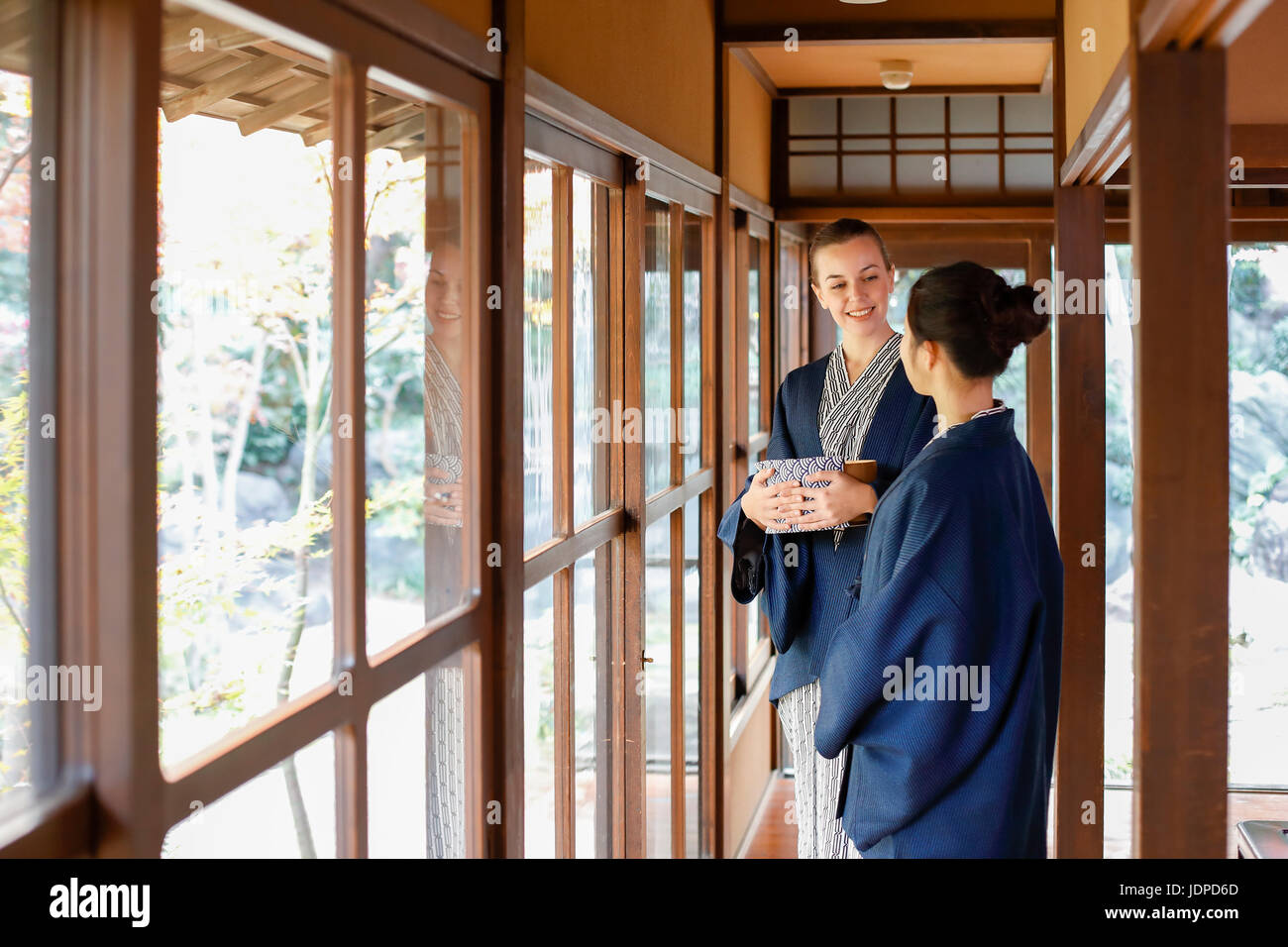 Caucasian woman wearing yukata with Japanese friend at traditional ryokan, Tokyo, Japan Stock Photo