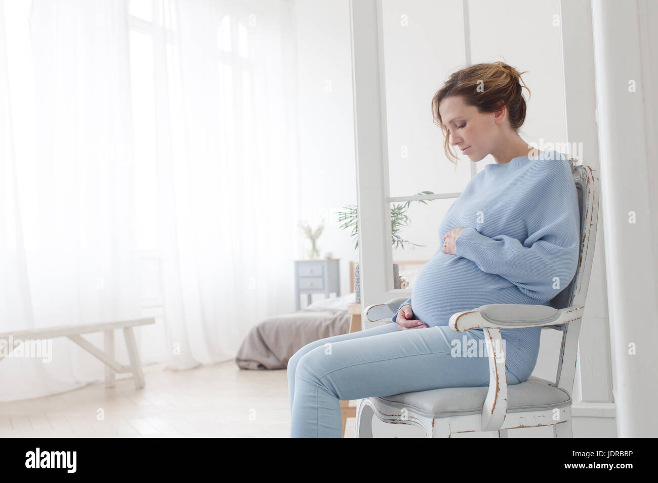 Pregnant woman sitting in chair Stock Photo Alamy