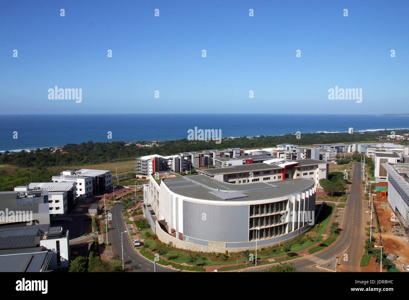 Above view of construction development and commercial and residential buildings urban coastal landscape against blue skyline in Durban, South Africa Stock Photo