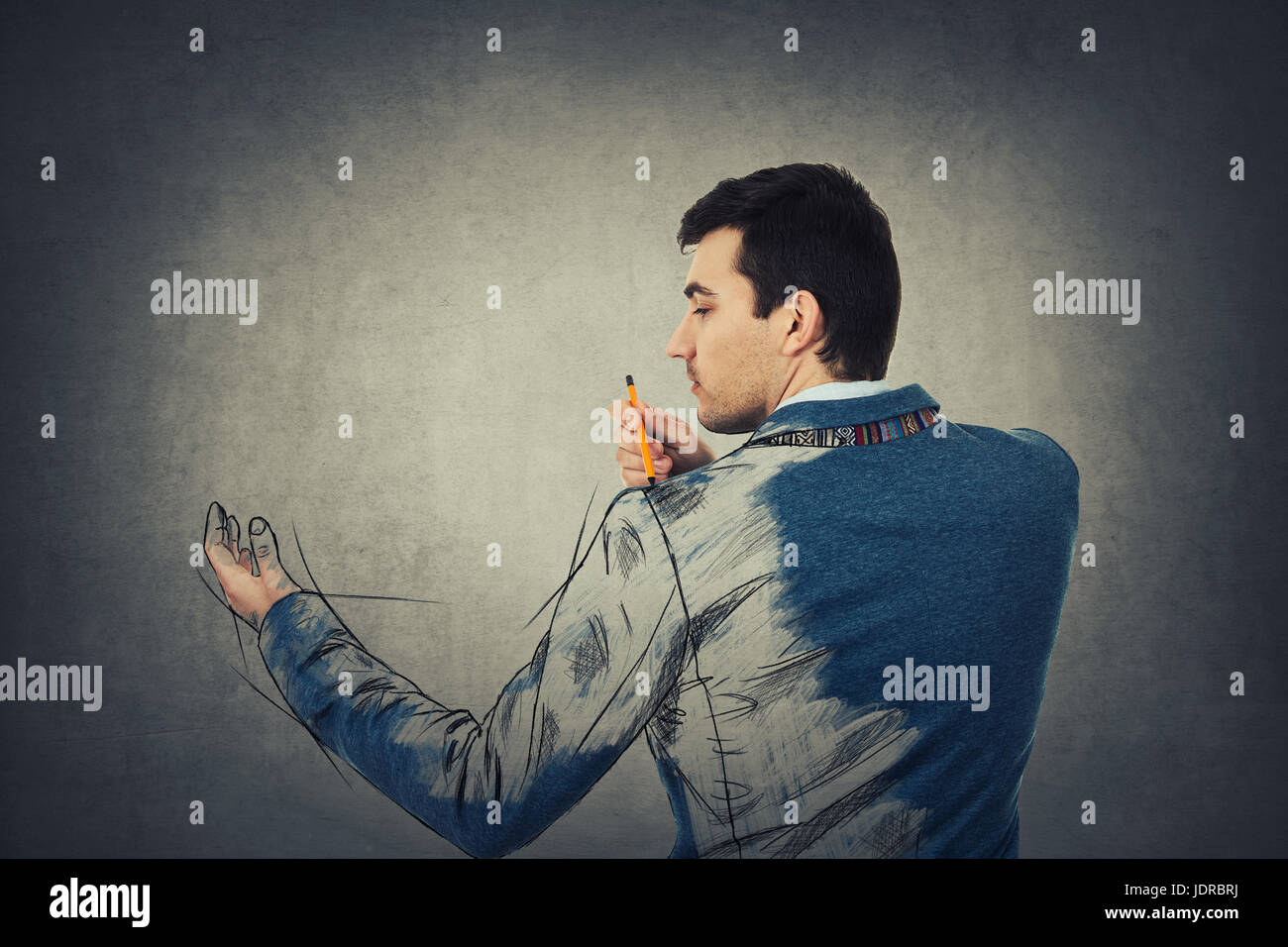 Businessman Personal development concept. Man create himself drawing a sketch of his body on grey wall background. Stock Photo