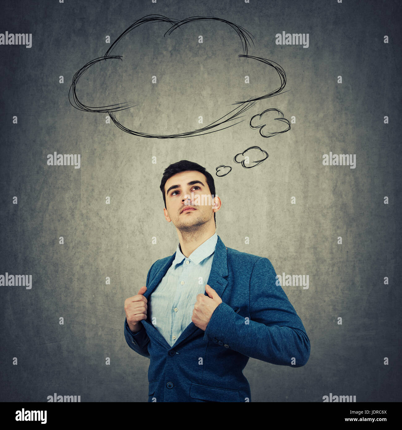 Young businessman acting with courage like a hero and look up thinking about something. Thought cloud sketch, bubble speech above his head isolated on Stock Photo