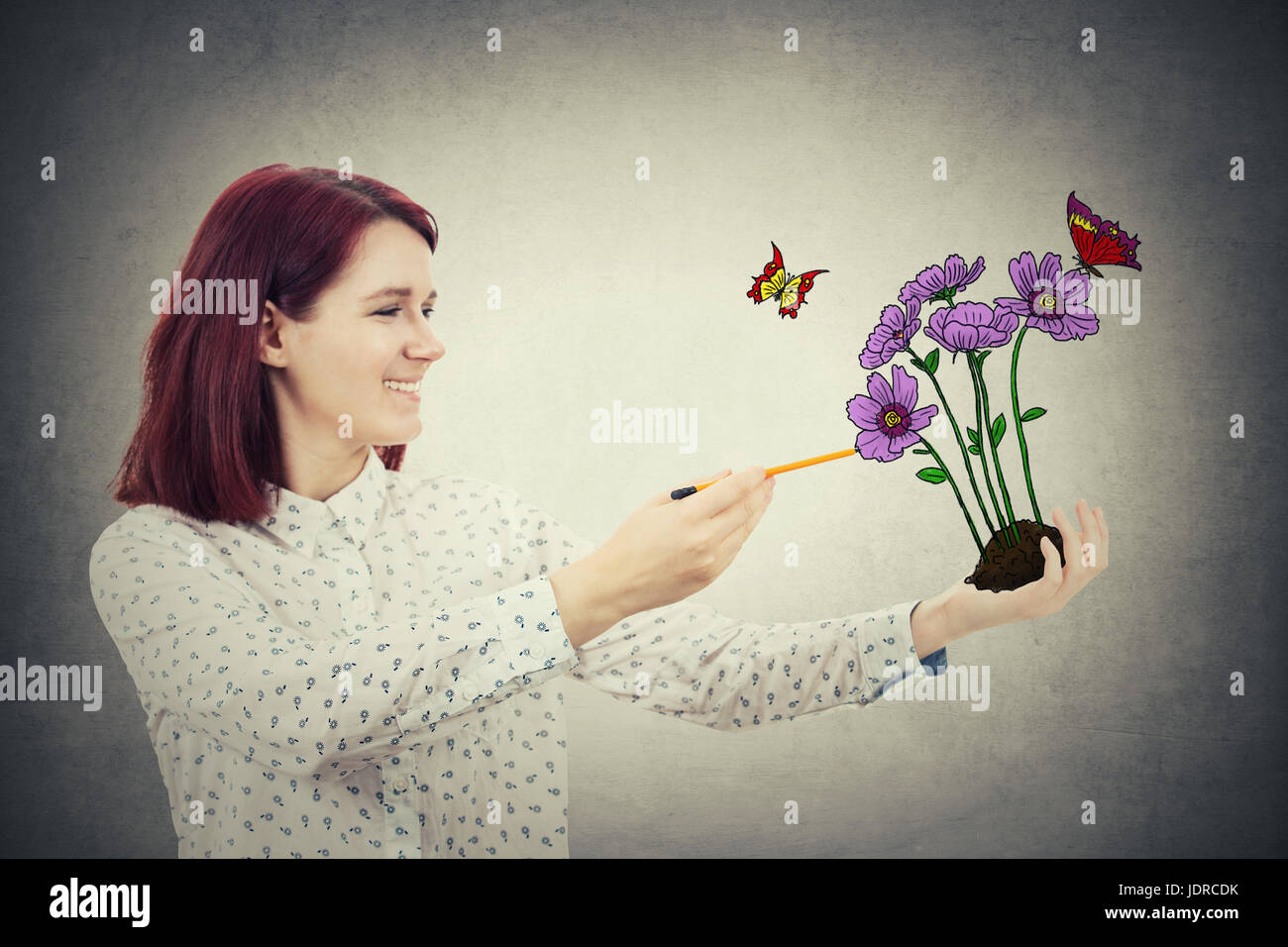 Young Smiling Girl With A Pencil In Her Hand Drawing Sketch A Flower Bunch Growing From Ground In Her Palm And Butterflies Flying Around Environment Stock Photo Alamy Young Smiling Girl With A Pencil In Her Hand Drawing Sketch A Flower Bunch Growing From Ground In Her Palm And Butterflies Flying Around Environment Stock Photo Alamy