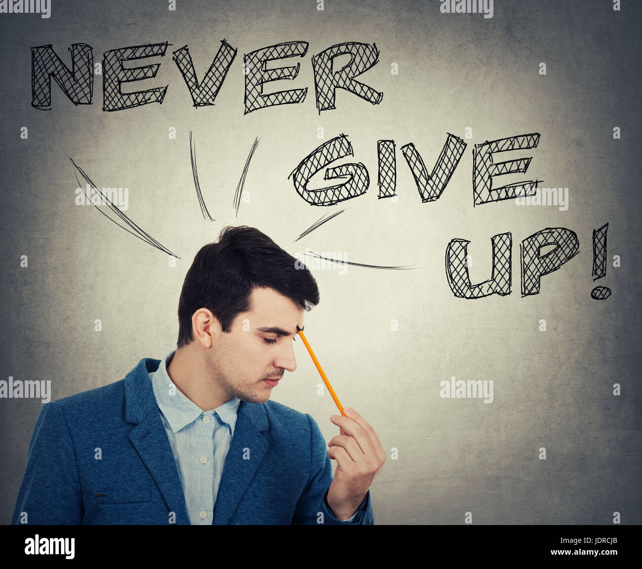 Thoughtful businessman holding a pencil pointed to face, drawing text over head. Never give up, positive thinking concept isolated on grey wall backgr Stock Photo