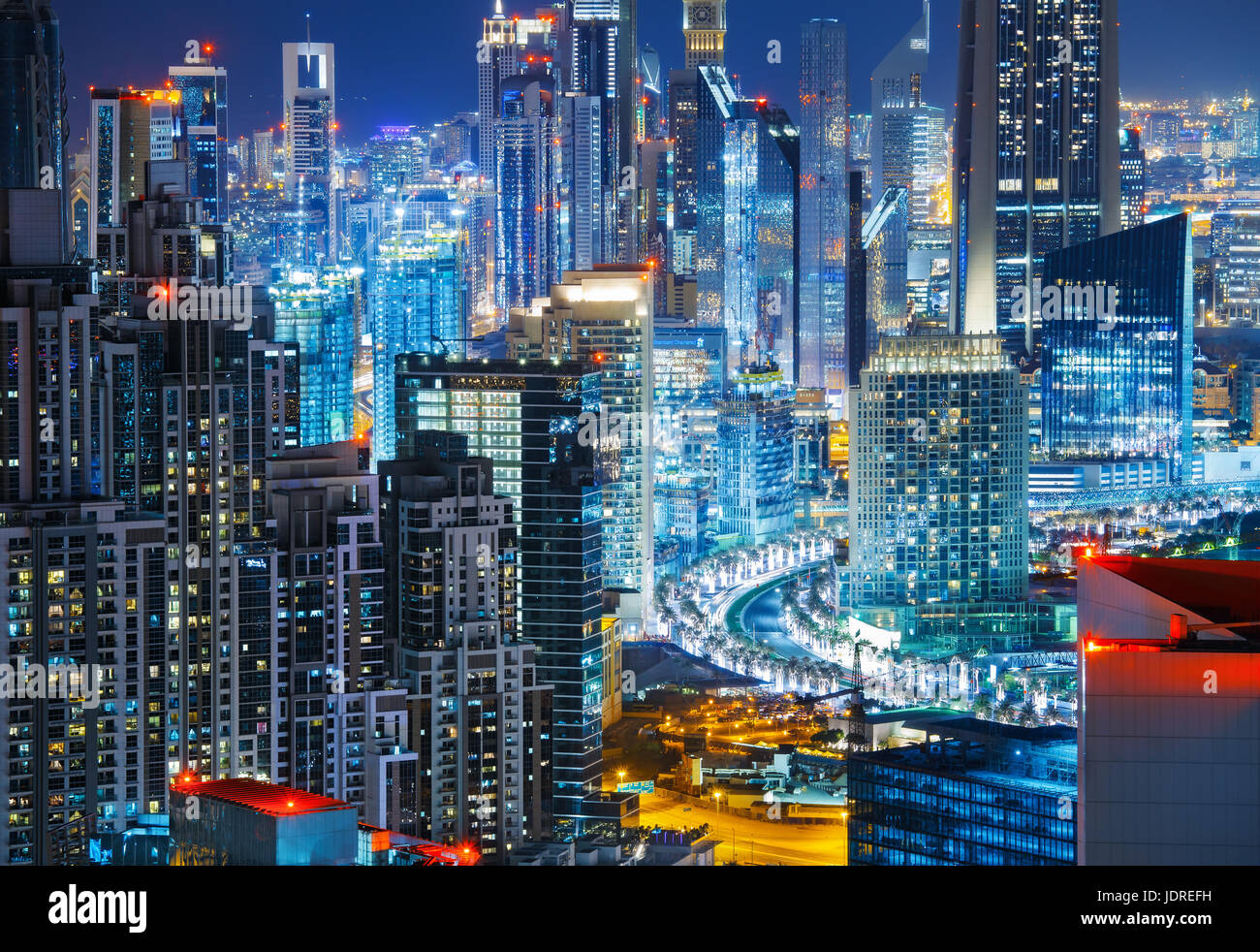 Spectacular elevated view over a big modern city at night with illuminated skyscrapers. Architecture of downtown Dubai, United Arab Emirates. Stock Photo