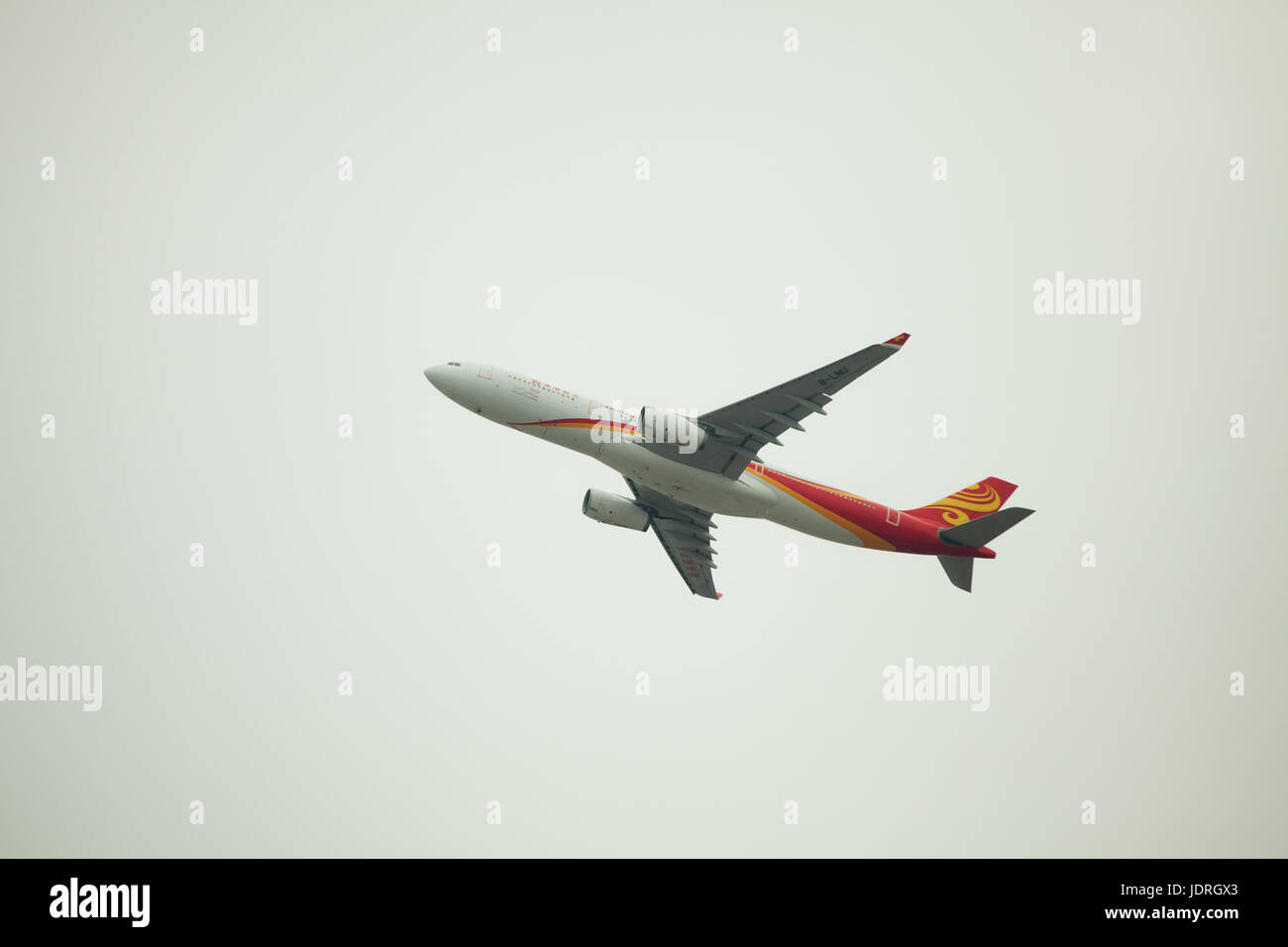 Hong Kong airlines airplane liftoff at Hong Kong international airport at foggy cloudy day; Side view at the plane from ground; Stock Photo