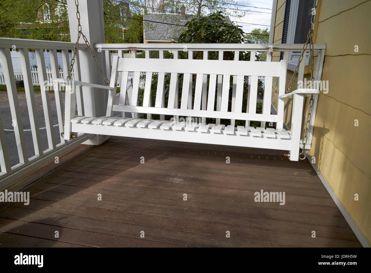 white wooden swing chair on a porch of a period home Boston USA Stock Photo