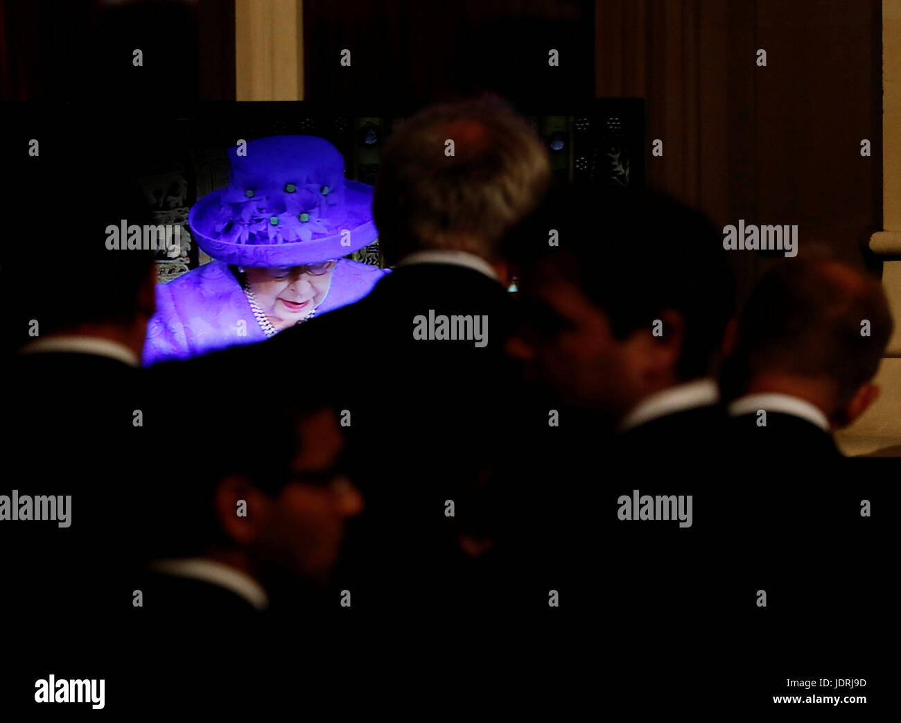 Members of the House of Commons watch the Queen's Speech on a television screen in the Peers