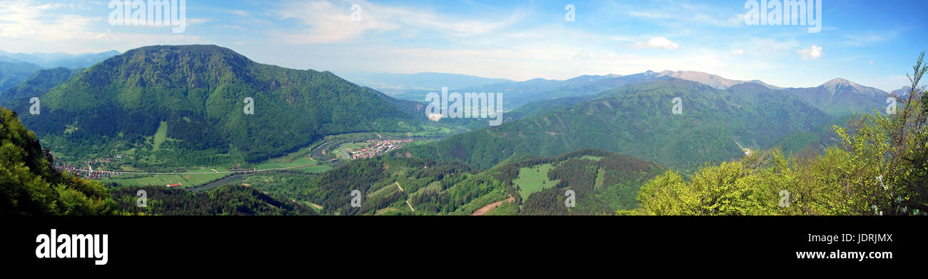spectacular panorama with Vah river valley with few villages, Velka Fatra and Mala Fatra mountain range and blue sky with clouds from view point near Stock Photo