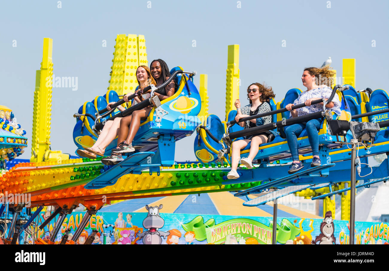 Group of friends riding on a Galaxia ride on Brighton Pier in the Summer. Stock Photo