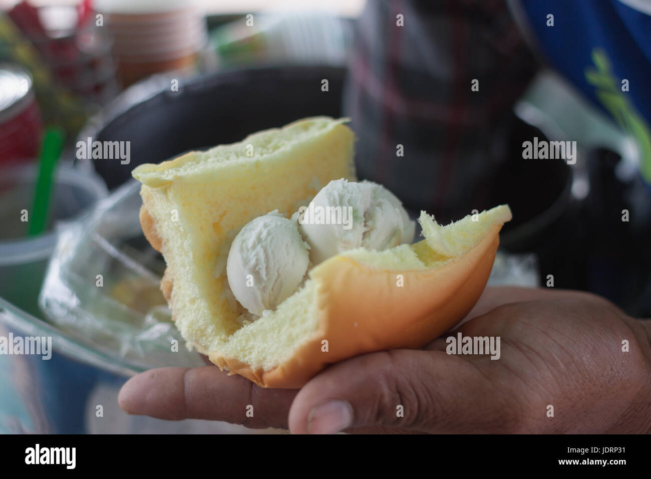 Saler scooping coconut Icecream topped with peanut and milk dressing