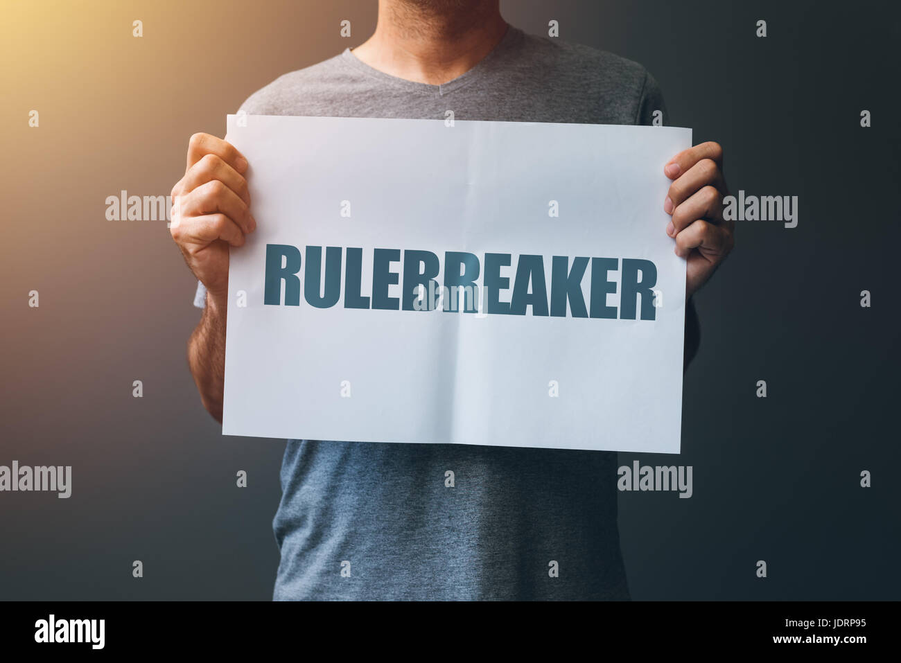 Rulebreaker attitude, person who breakes the rules concept with male holding poster Stock Photo