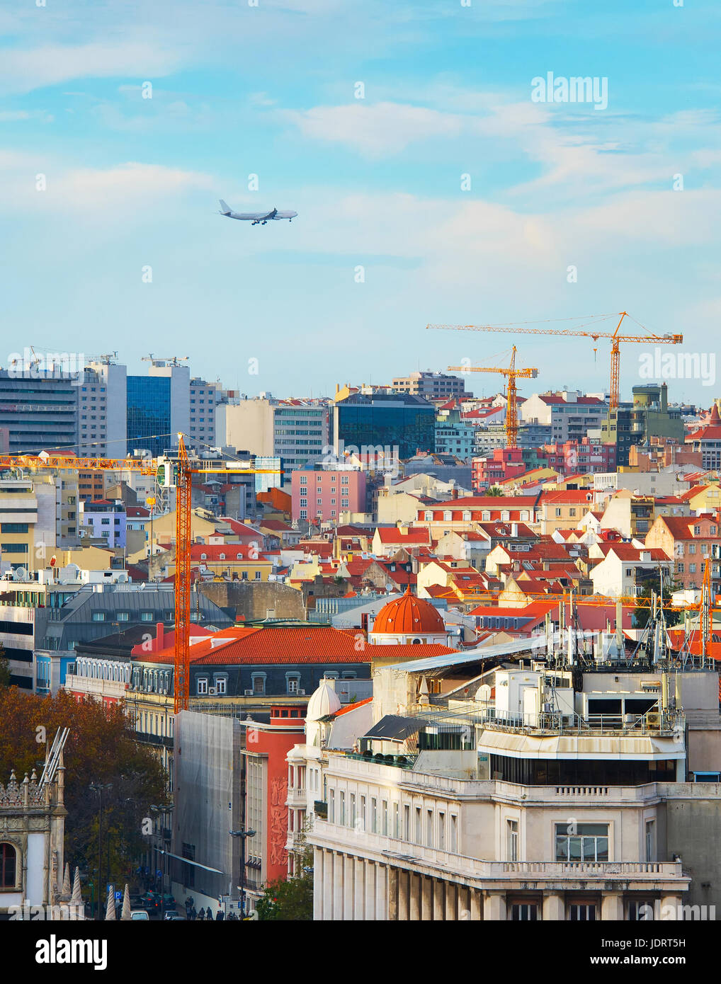 Airplane flying over Lisbon Downtown at sunset. Portugal Stock Photo