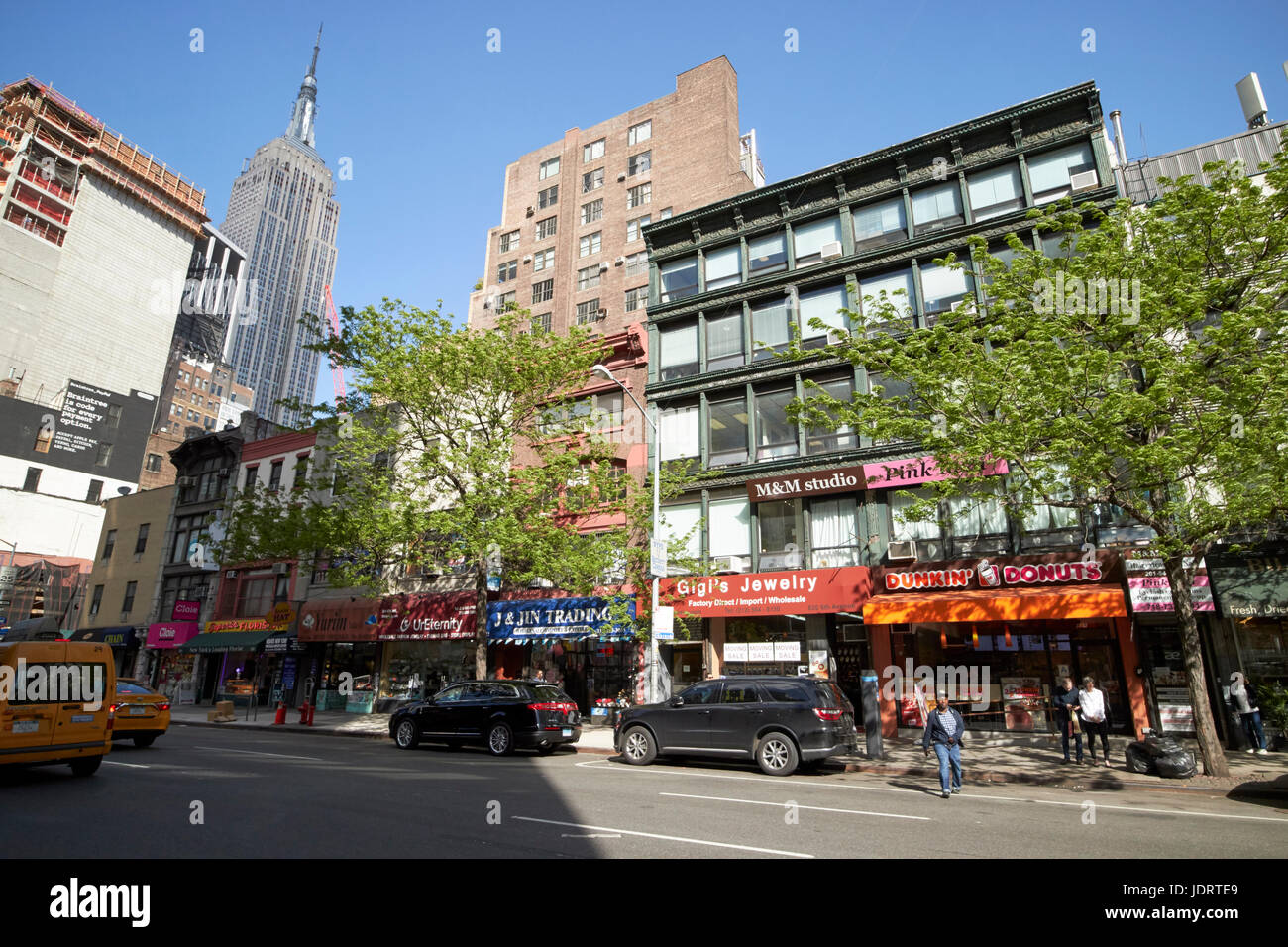 small shops on 6th avenue chelsea with view of the empire state building New York City USA Stock Photo