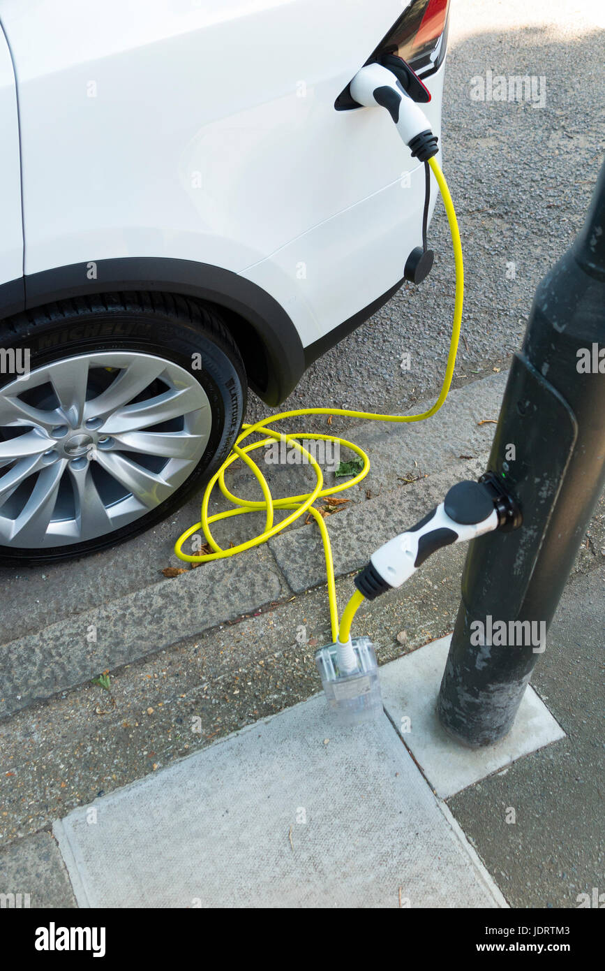 An electric car charger conversion by Ubitricity: smart cable on a street lamp which can now be used to charge an EV vehicle from lamp post (In this case a Tesla.) Twickenham UK Stock Photo