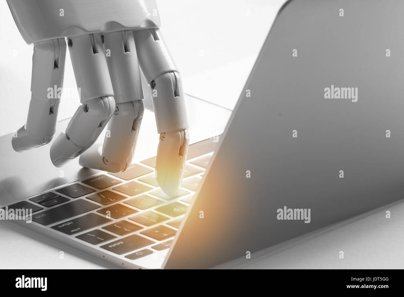 Artificial intelligence , robo advisor , chatbot , robotic concept. Robot finger point to laptop button with flare light effect. Stock Photo