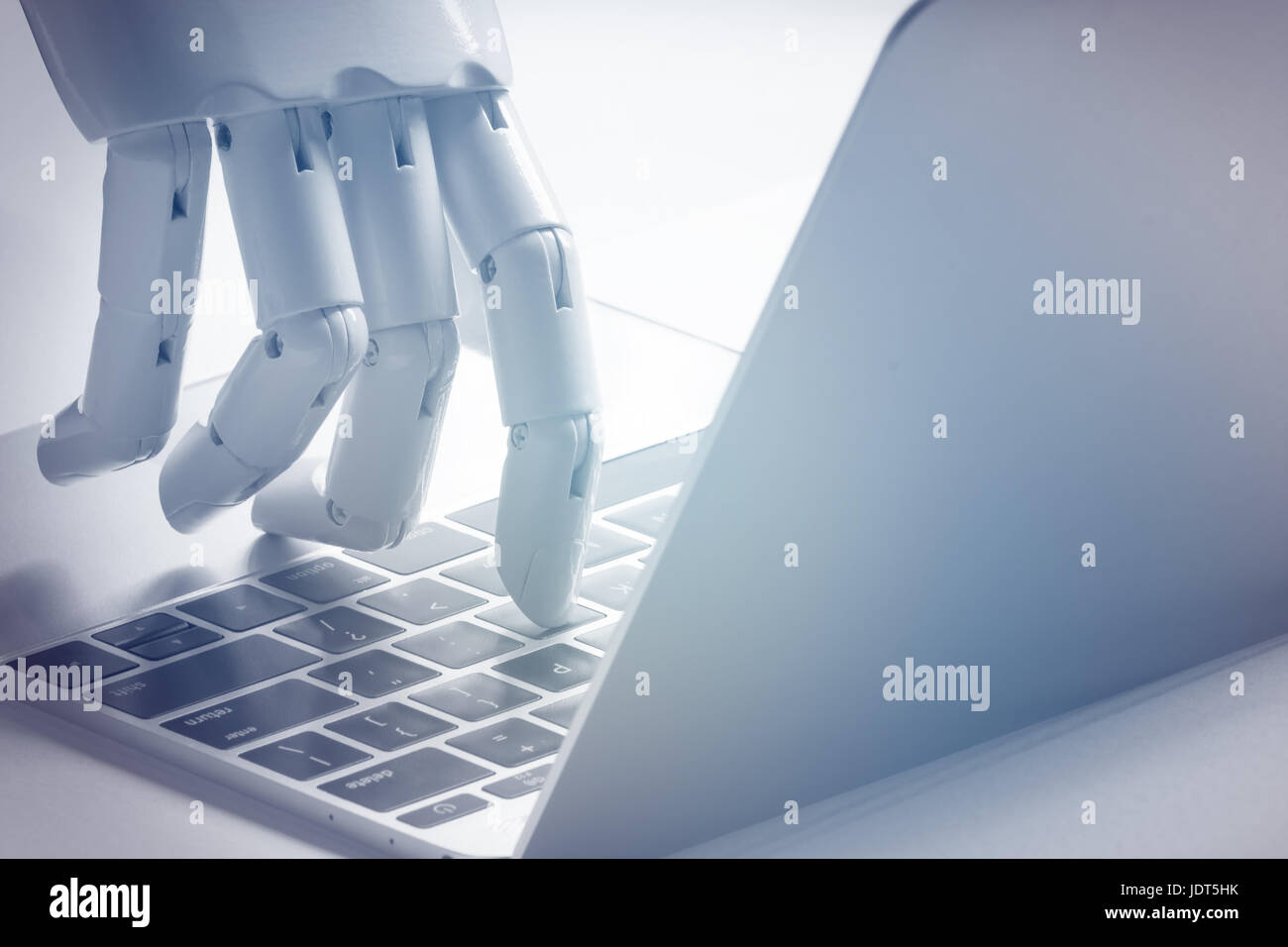 Chat bot , artificial intelligence , robo advisor , robotic concept. Robot finger point to laptop button. Blue tone. Stock Photo