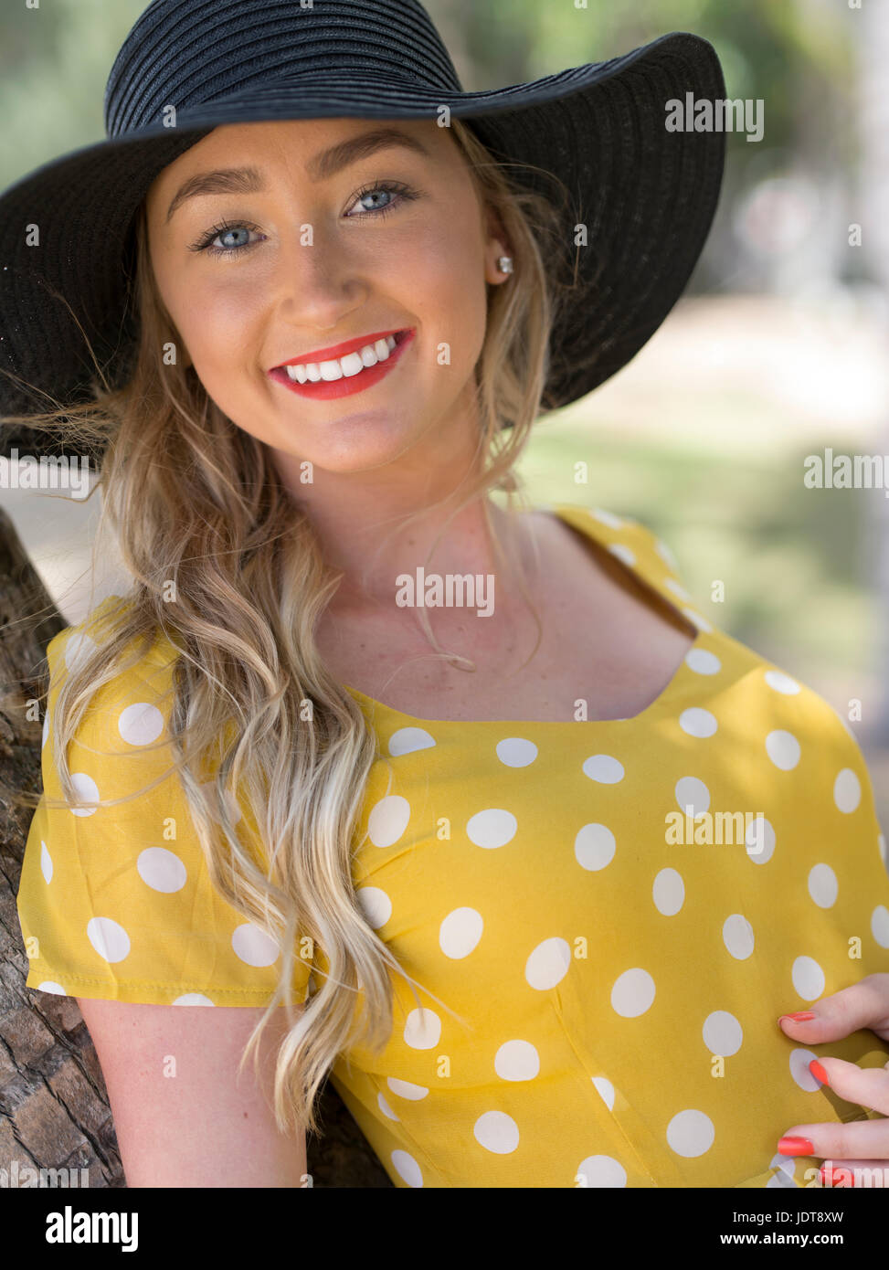 Young Australian woman in yellow polka dot dress relaxing at Palm Cove, near Cairns, Queensland, Australia Stock Photo