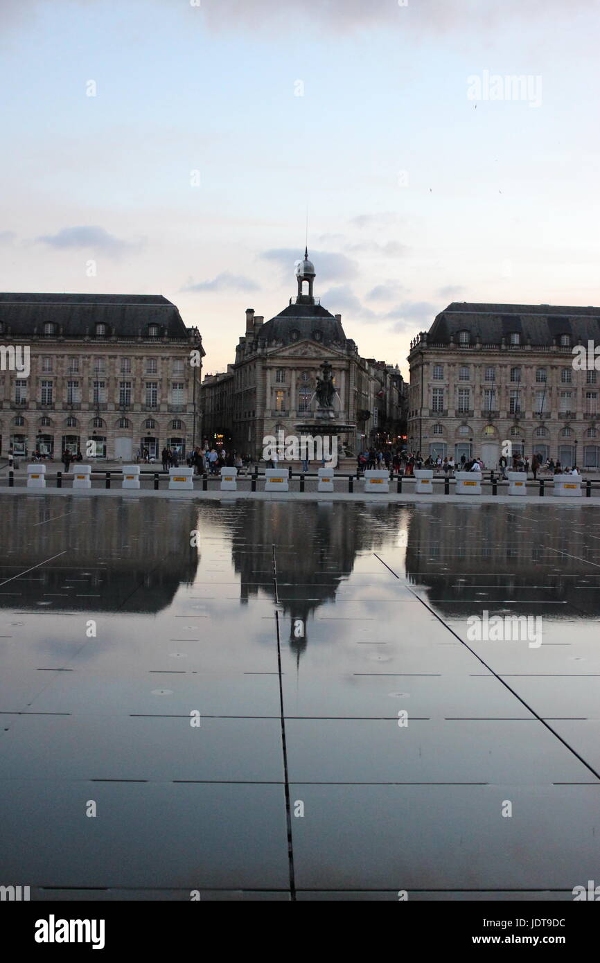 The Miroir d'Eau of Bordeaux reflecting the city as the sun goes down. Stock Photo