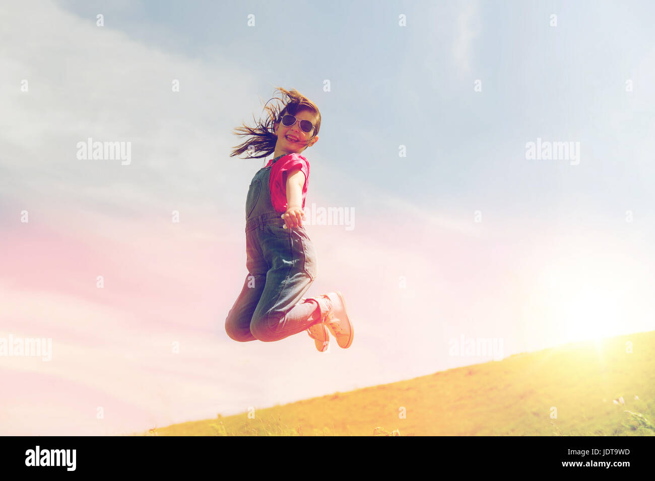 happy little girl jumping high outdoors Stock Photo - Alamy