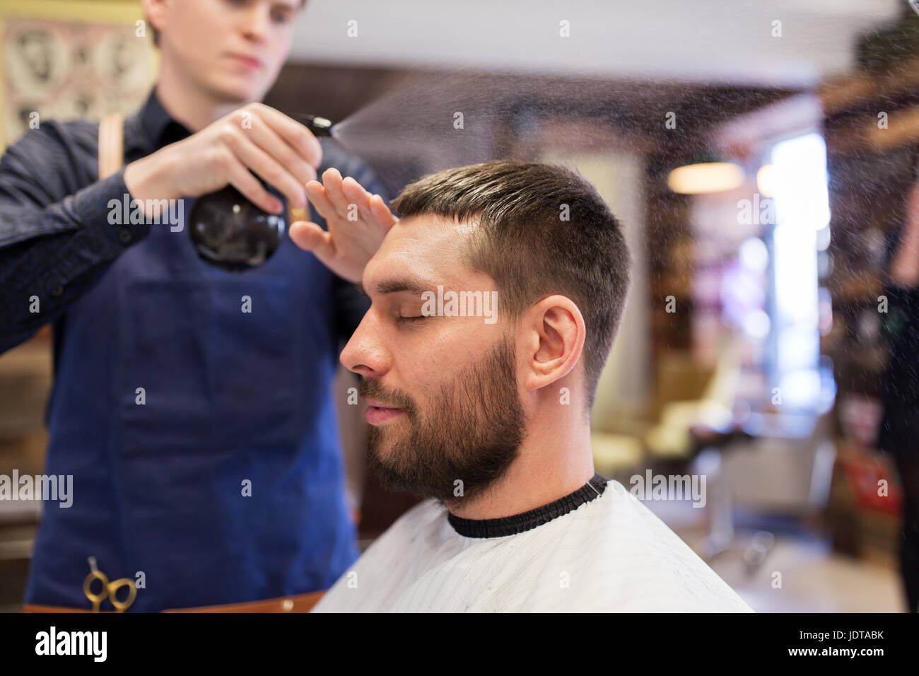 barber applying styling spray to male hair Stock Photo Alamy