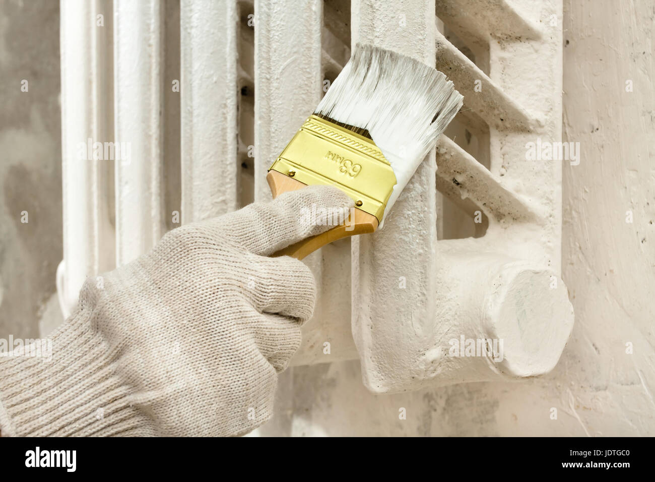 hand in glove painting radiator central heating with brush Stock Photo Alamy