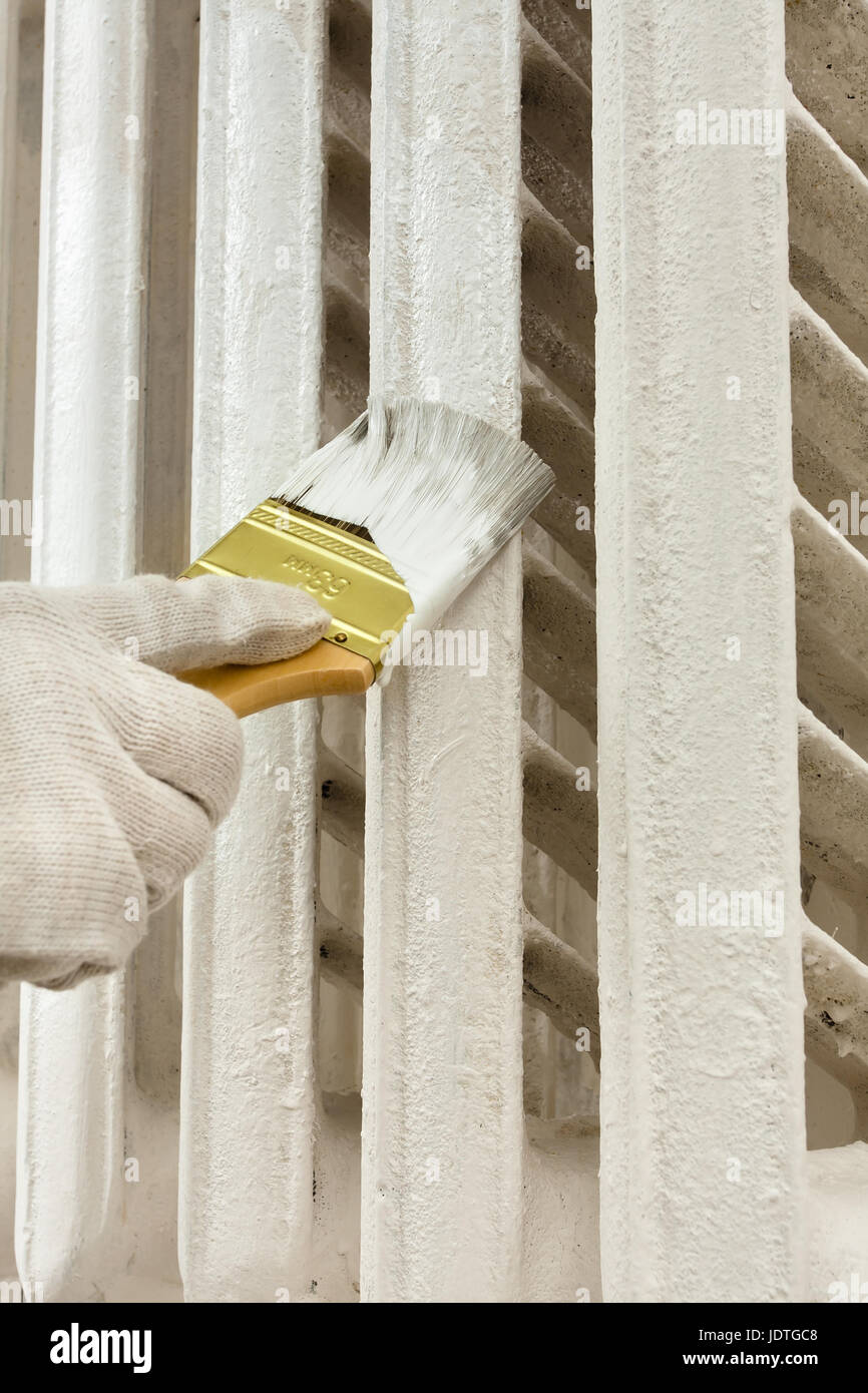 hand in glove painting radiator central heating Stock Photo