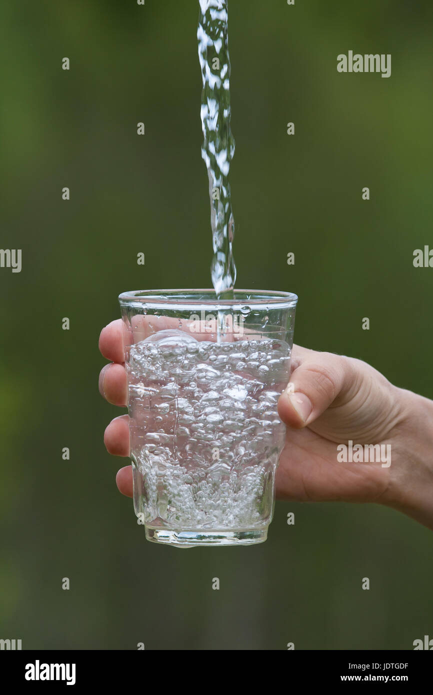 https://c8.alamy.com/comp/JDTGDF/hand-pouring-clean-natural-water-into-glass-on-blurred-background-JDTGDF.jpg