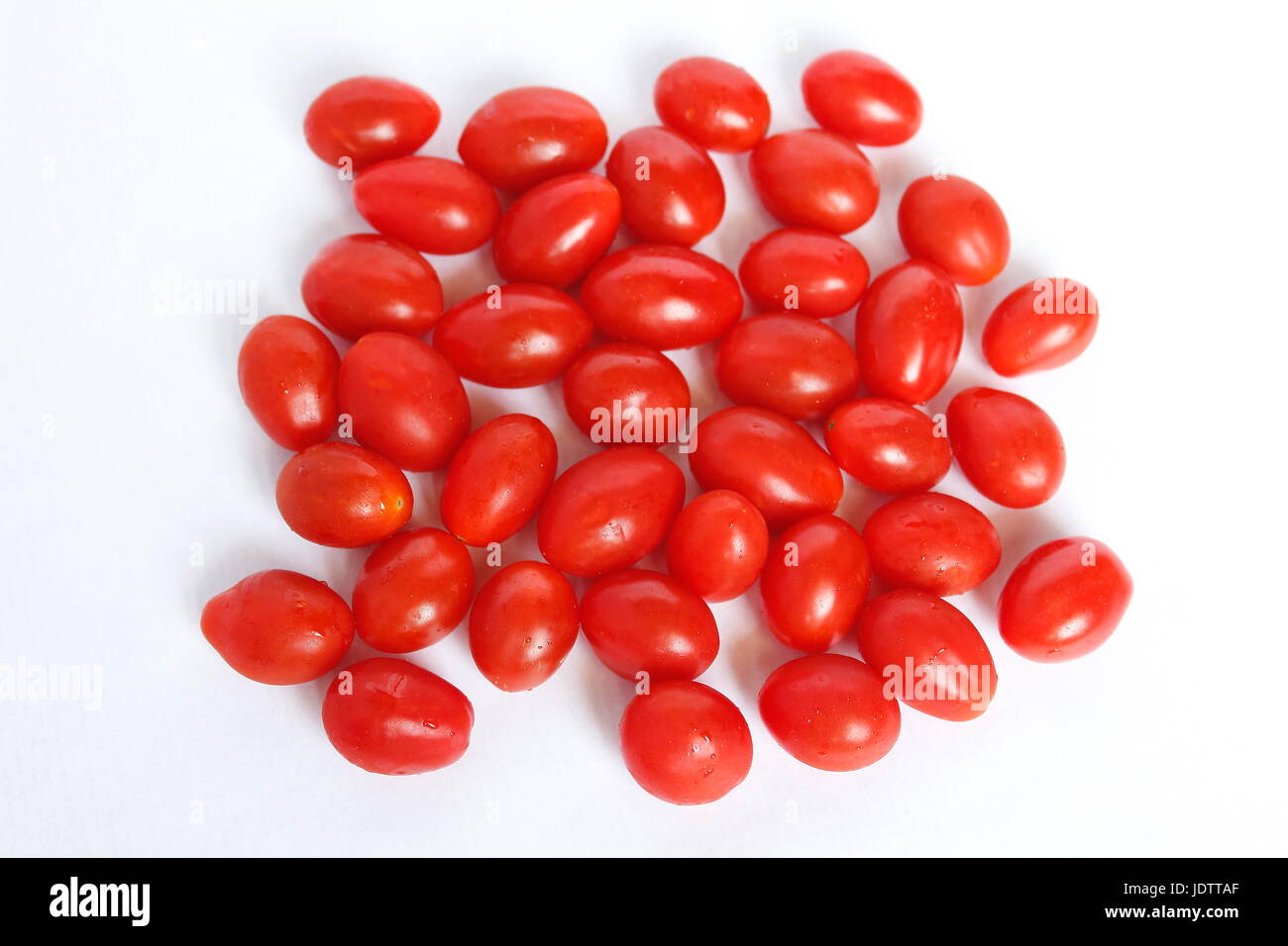 Small cherry tomatoes long red and fresh in group on white background Stock Photo