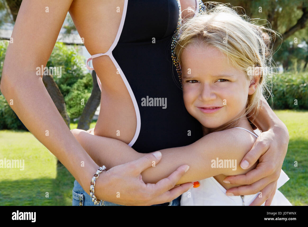 Close-up of a kid embracing her mother Stock Photo
