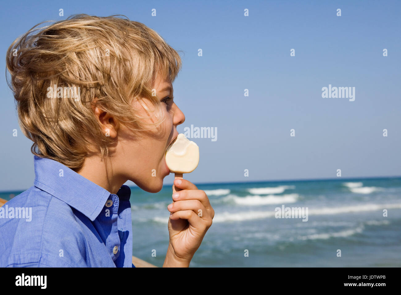 Boy eating an ice cream at a beach Stock Photo