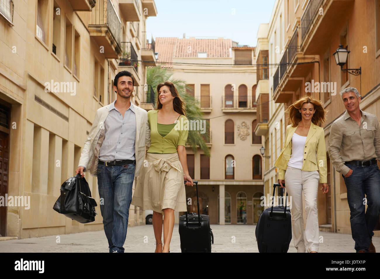 Two couples with cases walking Stock Photo