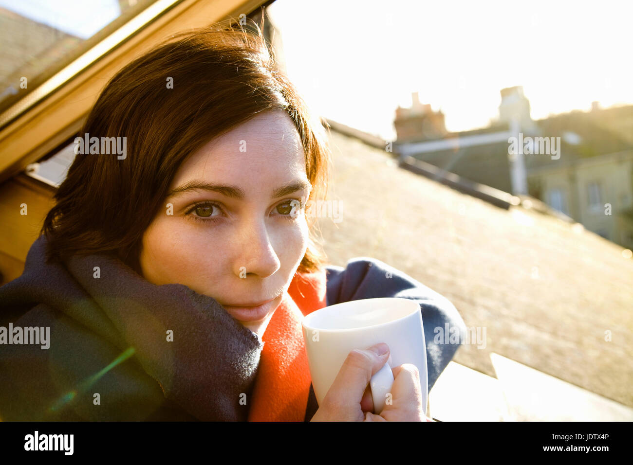 Woman with cup leaning out of window Stock Photo - Alamy