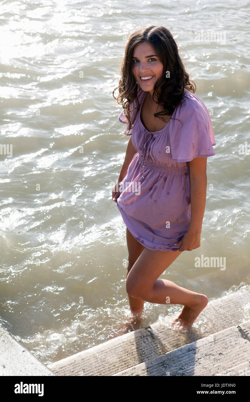 Woman wading in city river Stock Photo