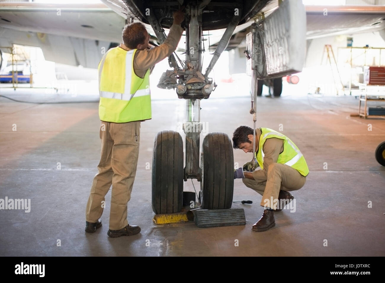 Aircraft workers checking wheels Stock Photo Alamy