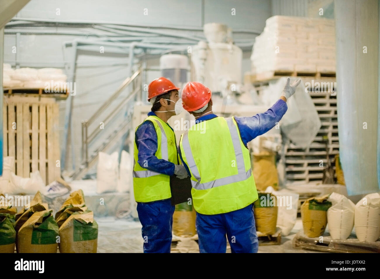 Workers in masks talking in factory Stock Photo - Alamy