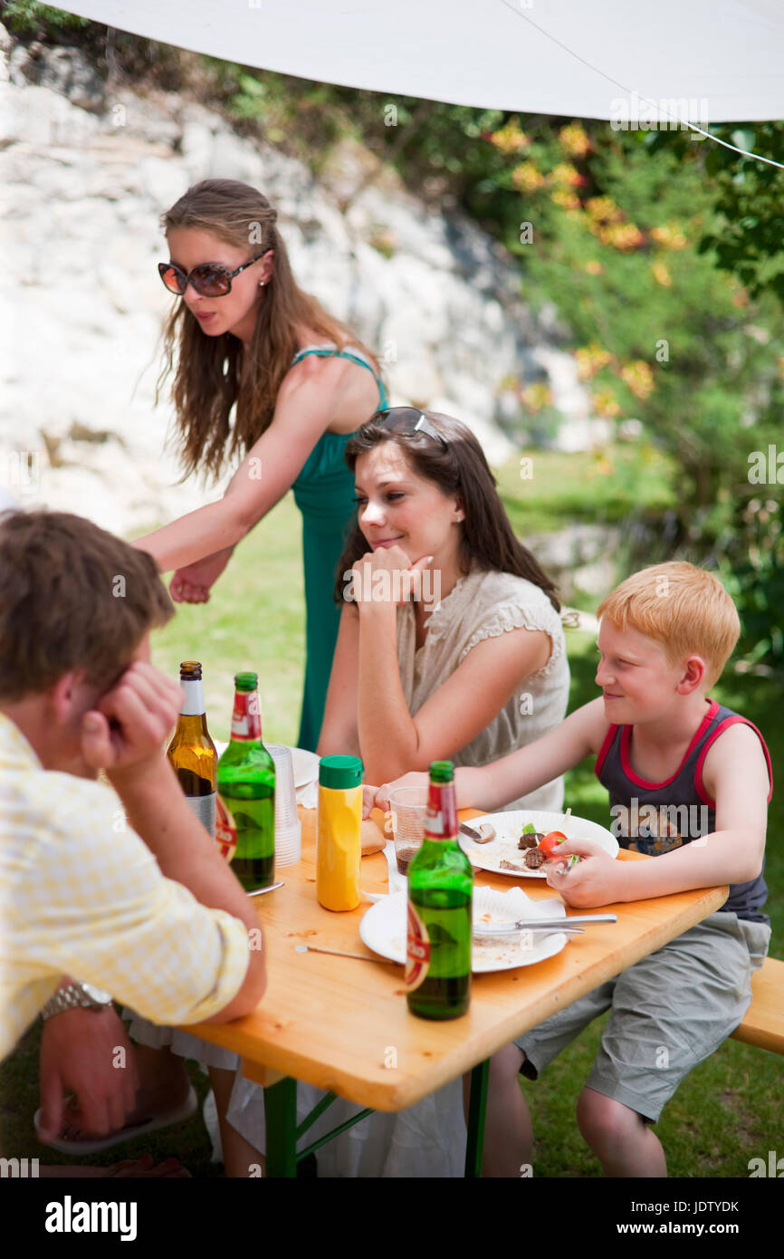 Family talking at table outdoors Stock Photo