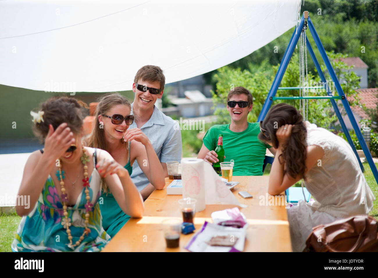 Friends laughing at table outdoors Stock Photo
