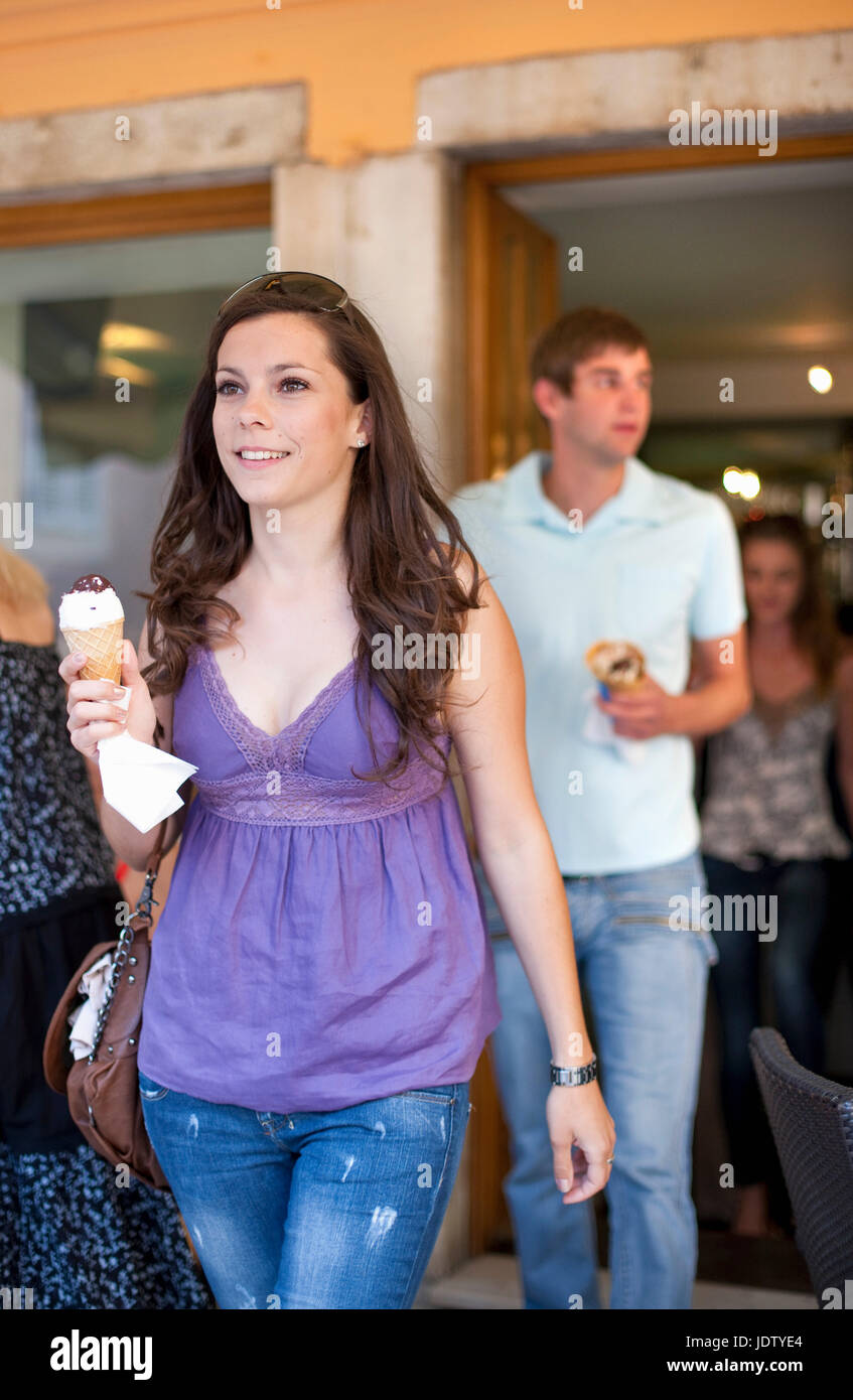 Woman carrying ice cream cone outdoors Stock Photo