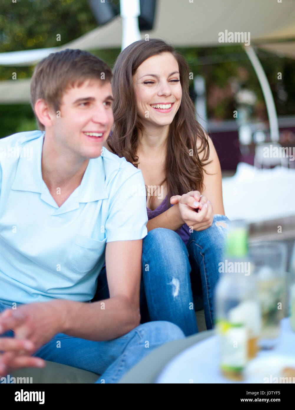 Smiling couple sitting together outdoors Stock Photo